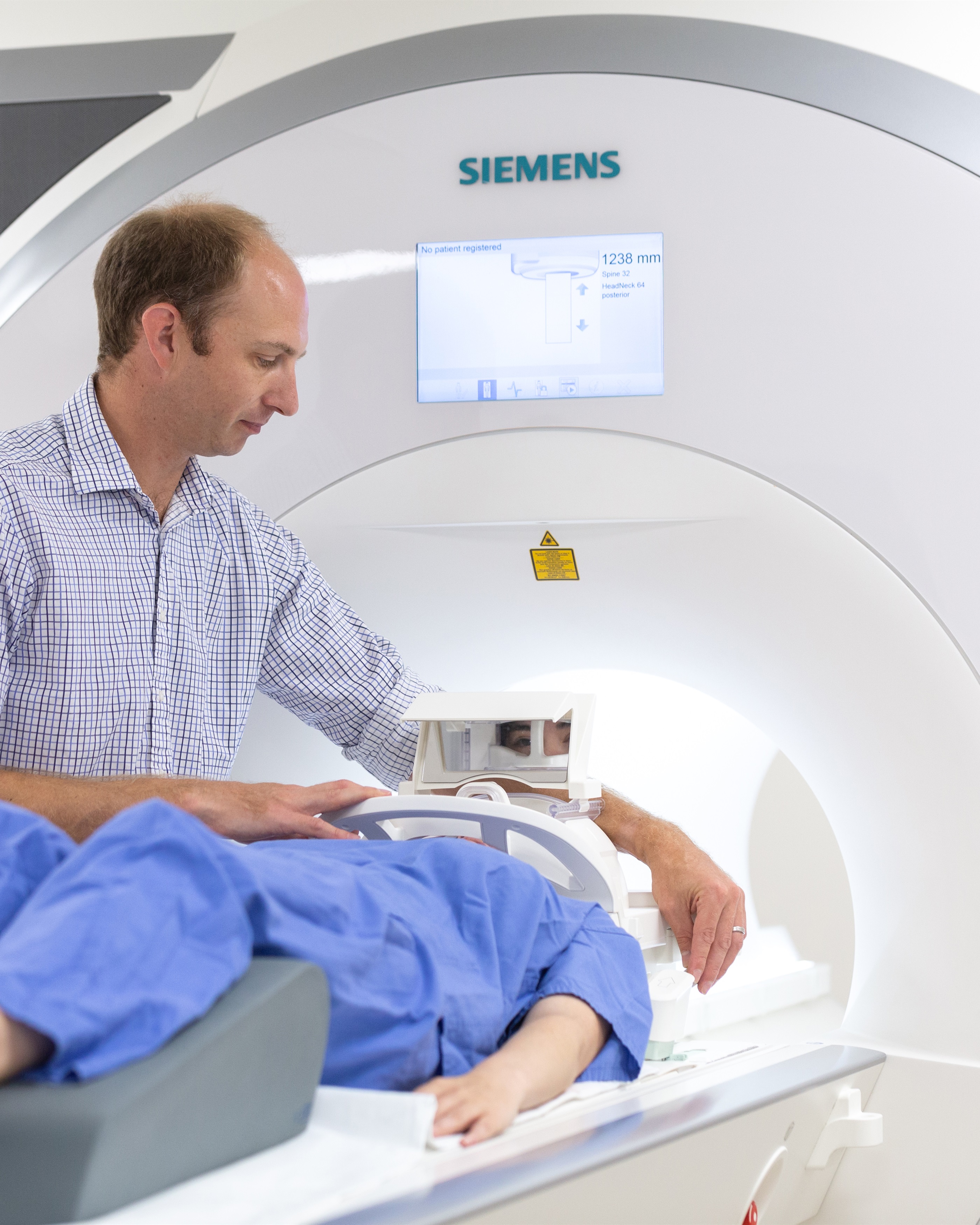 Superintendent Radiographer putting patient into MRI machine